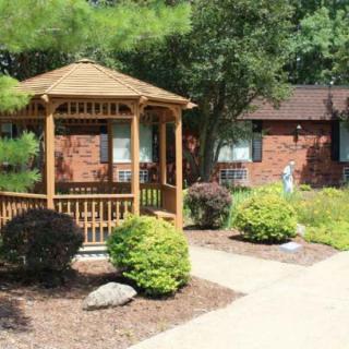A quaint gazebo surrounded by well-maintained landscaping in a garden setting.