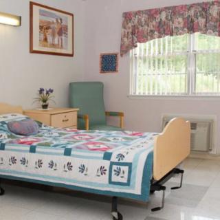 A hospital room with a single bed and comfortable decor.
