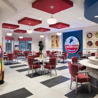 A retro-themed diner interior with red seating and a jukebox.