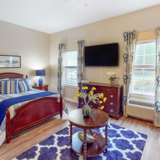 A cozy bedroom with elegant furnishings and natural light streaming in through the windows.