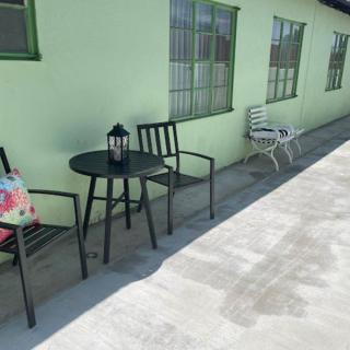 Outdoor seating area with chairs, a table, and a lantern on a concrete patio.
