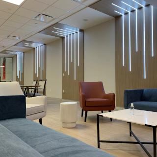 A modern office lounge area with comfortable seating and sleek lighting fixtures.