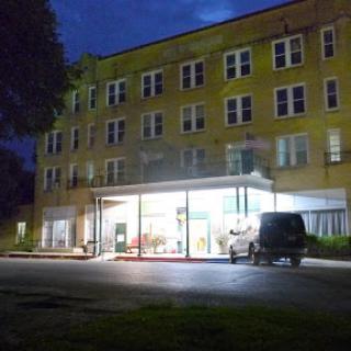 A brightly lit hotel entrance at night, showcasing a modern architectural design.