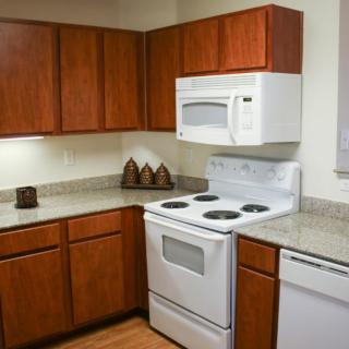 A modern kitchen with wooden cabinets and white appliances.