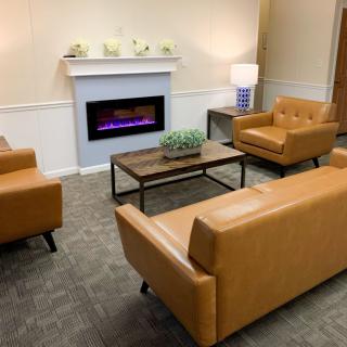 A cozy living room with modern furniture and a fireplace.