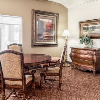 A traditionally styled dining room with elegant wooden furniture and artwork on the walls.