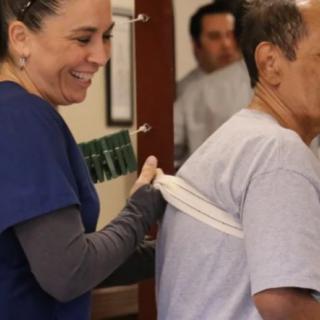A healthcare professional assists a patient with mobility exercises.