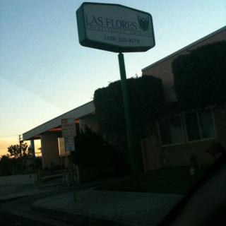A business sign in front of a building during sunset.