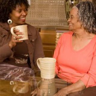 Two women enjoying a casual conversation over coffee indoors.