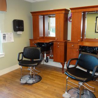 An interior view of a hair salon with two chairs and mirrors.