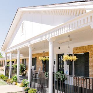 A charming modern house showcasing a welcoming porch adorned with hanging plants.
