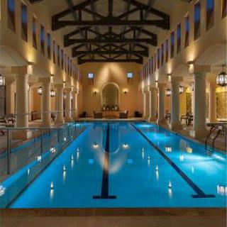 An elegant indoor swimming pool featuring modern architecture and soothing ambient lighting.