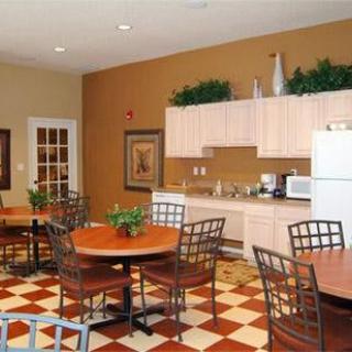 A cozy kitchen and dining area with wooden tables, metal chairs, and tiled flooring.
