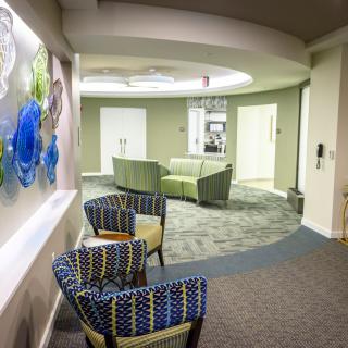 A modern lobby area with comfortable seating and decorative artwork on the wall.