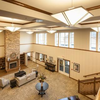Spacious lobby area with modern lighting, comfortable seating, and a brick fireplace.