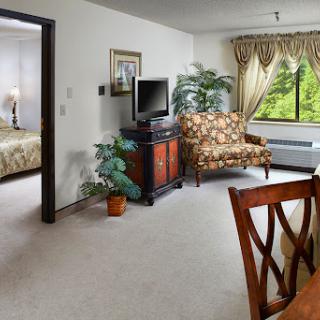 A cozy living area featuring a TV, an armchair, and a view through the window.