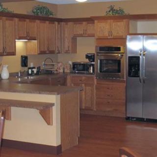 A modern kitchen with wood cabinets and stainless steel appliances, featuring a central island.