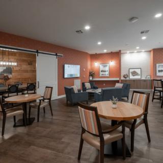 A cozy lounge area with seating arrangements, including tables, chairs, and sofas.
