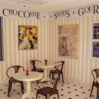 A cozy cafe corner decorated with sweet-themed artwork, perfect for enjoying chocolate treats.