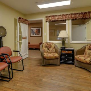 A cozy waiting room with chairs and a lamp.