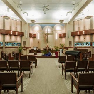 Interior view of a church with arranged seating facing the altar.