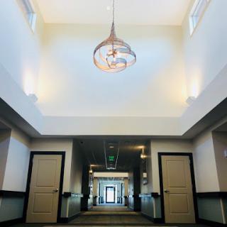 A spacious and elegantly designed hallway featuring a stylish chandelier.