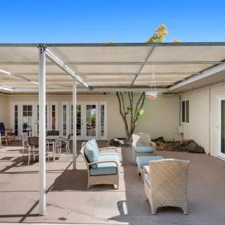 A sunny patio with comfortable outdoor seating and a pergola.