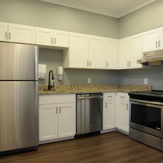 A modern kitchen with stainless steel appliances and white cabinets.