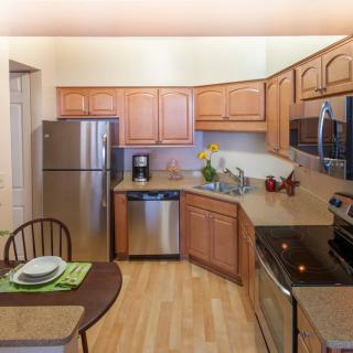 A modern kitchen with stainless steel appliances and wooden cabinets.