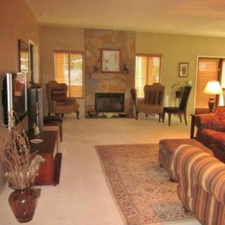 A cozy living room with a fireplace, comfortable seating, and warm decor.
