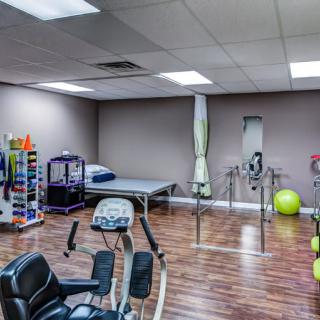 A spacious physical therapy room equipped with various rehabilitation and exercise equipment.