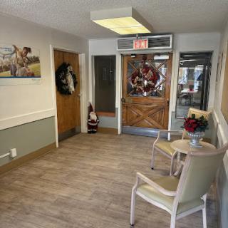 A cozy waiting area featuring wooden doors, decorative wall art, and comfortable seating.