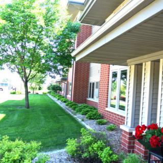 A suburban home with a neatly landscaped yard featuring lush greenery and vibrant flowers.