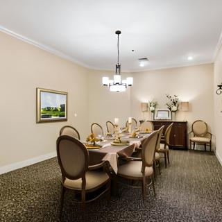 Elegantly decorated dining room with a chandelier and a set dining table.