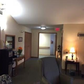 A cozy interior featuring a hallway and living room area, complete with furniture and soft lighting.
