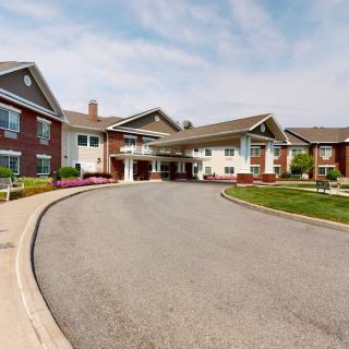 A residential building with a circular driveway and well-maintained landscaping.