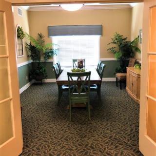 A cozy dining room with a table, chairs, and decorative plants.