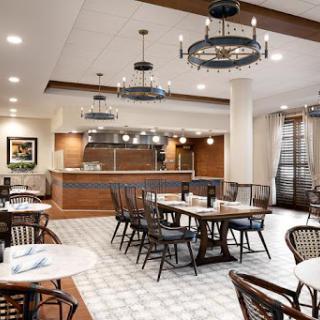 A spacious and inviting restaurant interior with modern decor and an open kitchen.