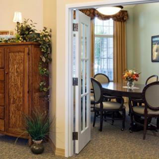 A cozy dining room with a wooden cabinet and a table set for guests.