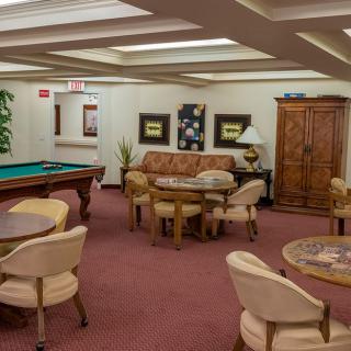 A cozy game room featuring a pool table, comfortable seating, and elegant decor.
