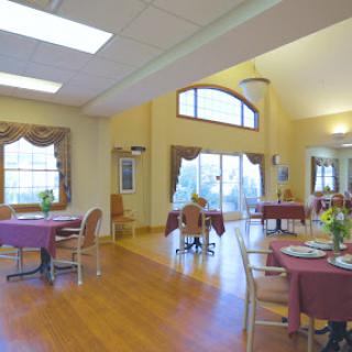 A spacious dining area featuring elegantly set tables and abundant natural light.