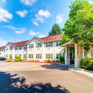 A sunny view of a residential building with trees and a clear blue sky.