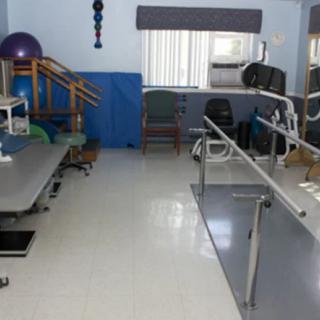 A physical therapy room equipped with exercise and rehabilitation equipment.