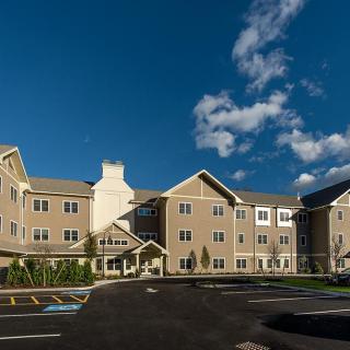 A modern residential building under a clear blue sky with scattered clouds.