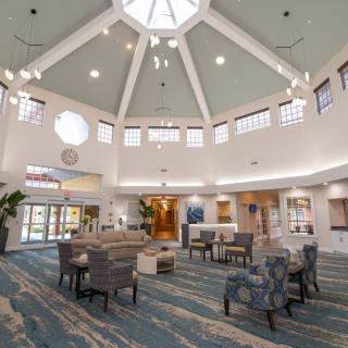 A modern lobby with comfortable seating and a high ceiling with abundant natural light.