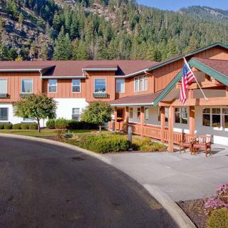 A cozy retirement home nestled in a scenic mountain landscape with an American flag at the entrance.