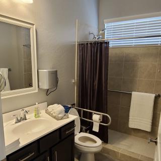 A modern bathroom with a sink, toilet, and shower area.
