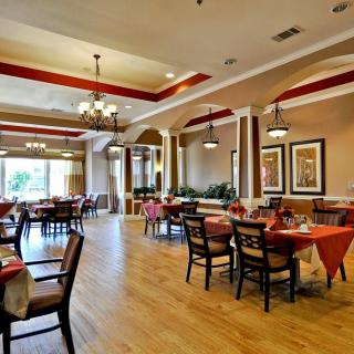 A spacious and elegantly decorated restaurant dining area with neatly arranged tables and chairs.