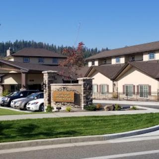 A welcoming residential facility surrounded by well-maintained landscaping and clear skies.