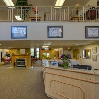 A reception area with a wooden desk, artwork on the walls, and comfortable seating.